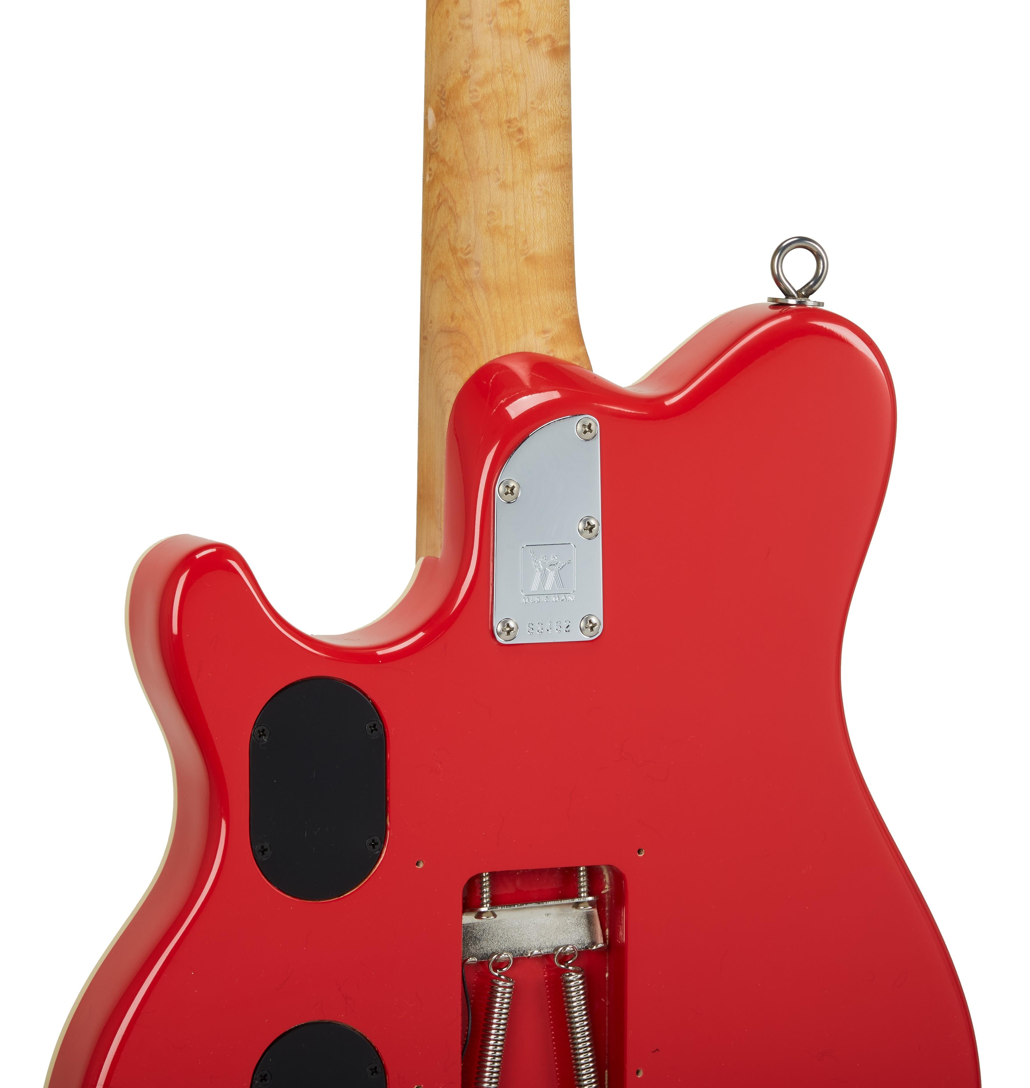the back of a red electric guitar with a tag that says ' fender ' on it