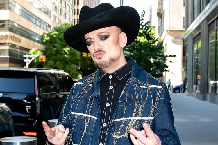 a man is wearing a blue jean jacket and black hat