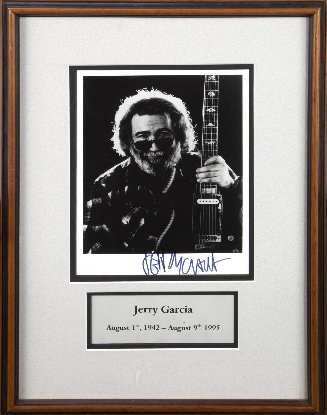 a framed photo of jerry garcia holding a guitar