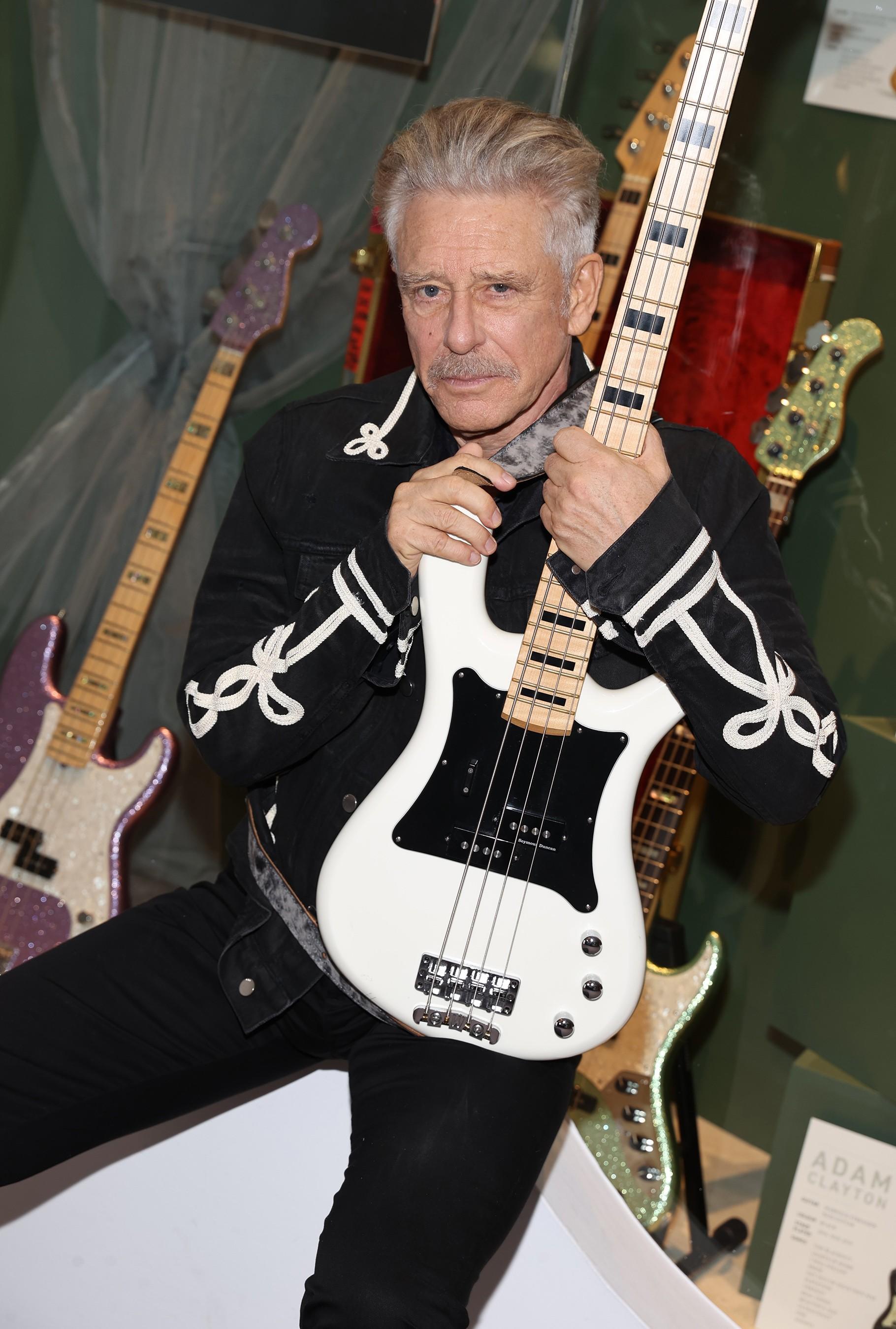 a man is pictured holding a white and black guitar