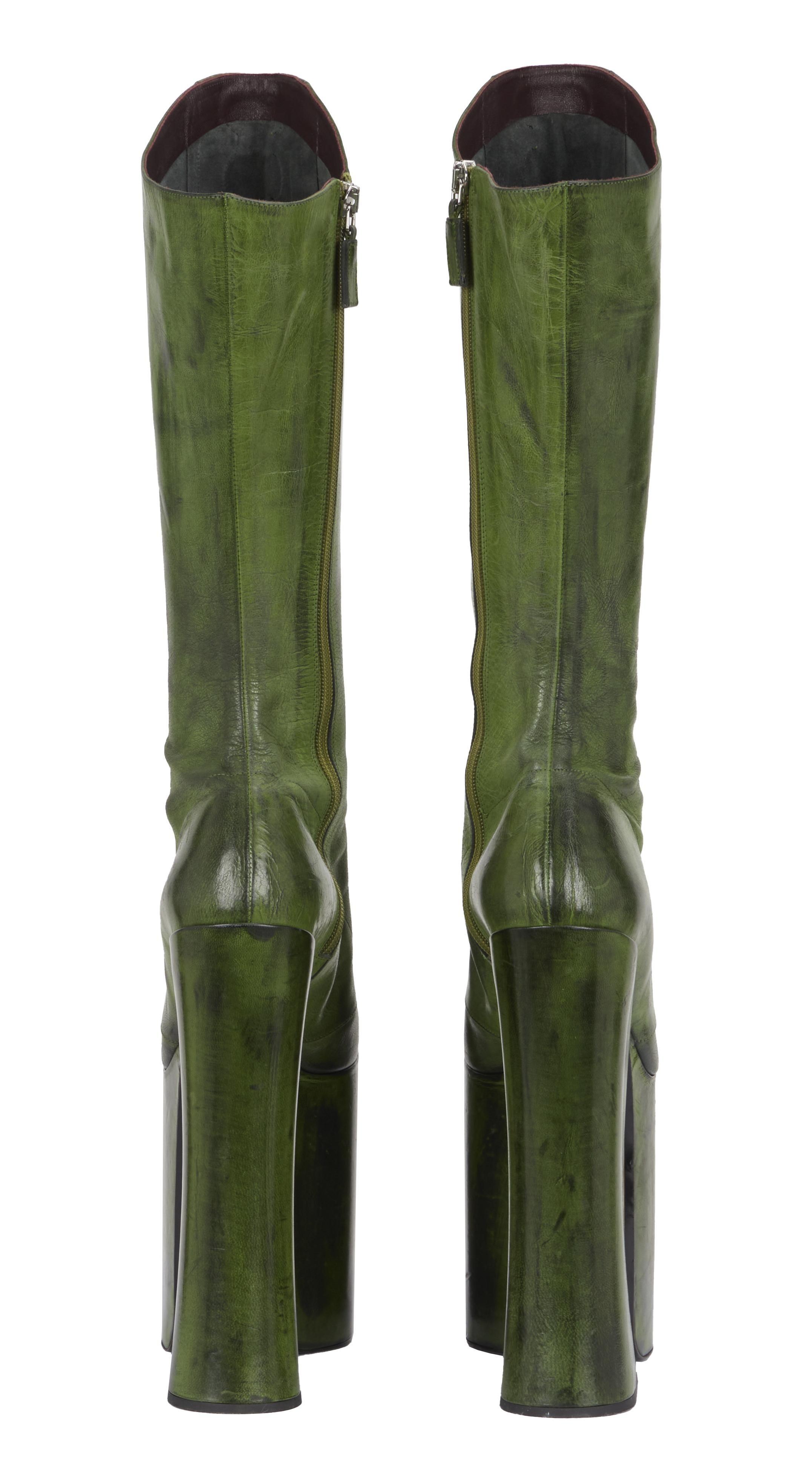 a pair of green platform boots on a white background