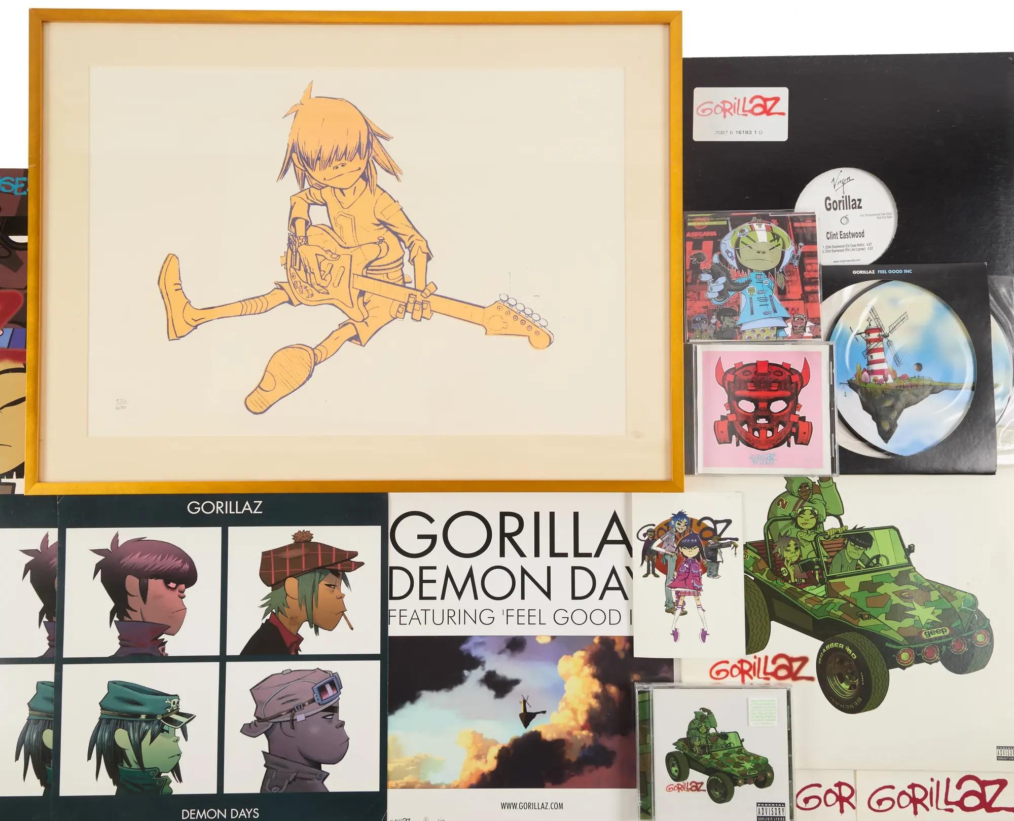 A collection of Gorillaz artwork and music releases, featuring a framed drawing of a character playing guitar, album covers, and discs.