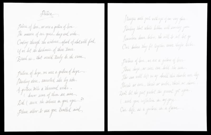 Two white sheets of paper side-by-side with handwritten light gray text that appears to be a poem or song lyrics.