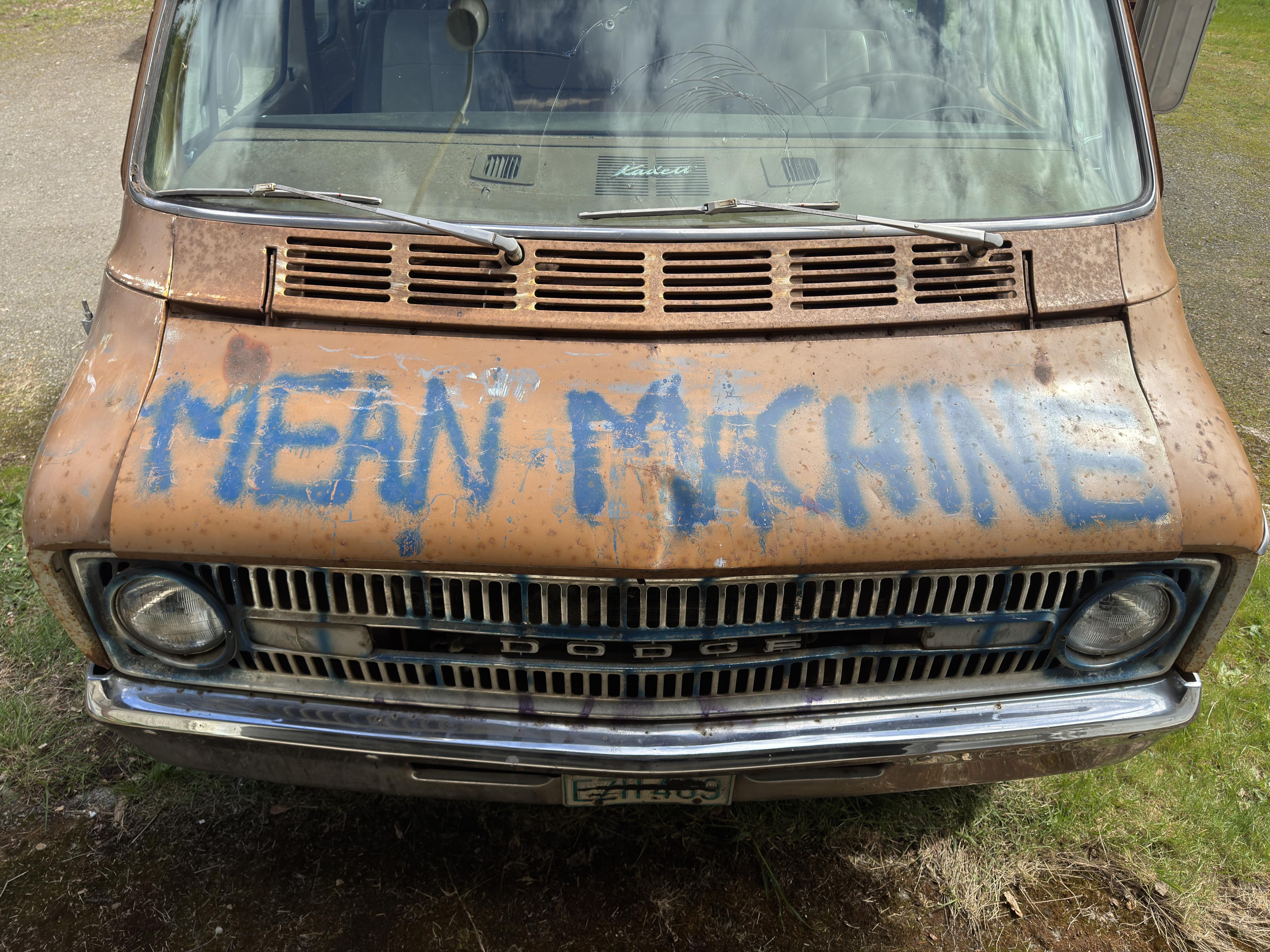 mean machine is spray painted on the hood of a van
