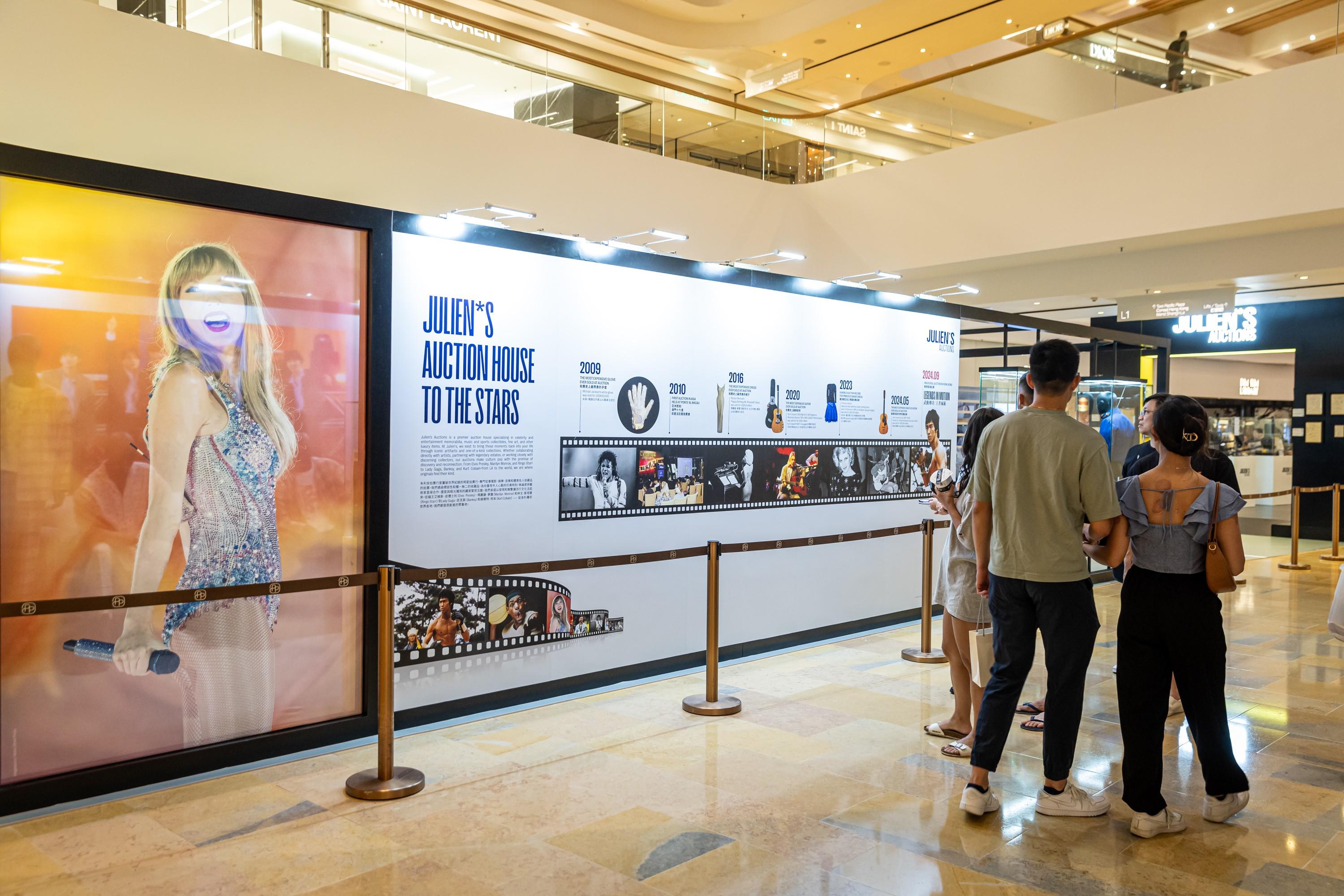 a group of people are standing in front of a wall in a mall .