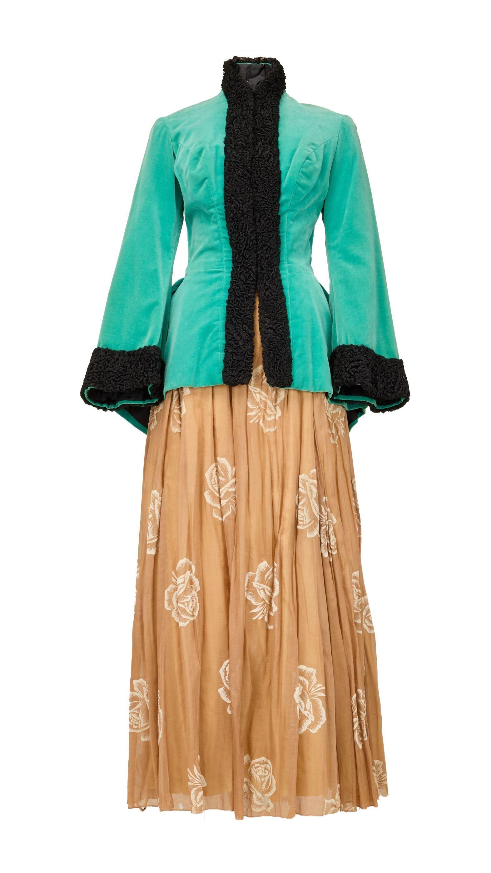 a green jacket with gold floral dress