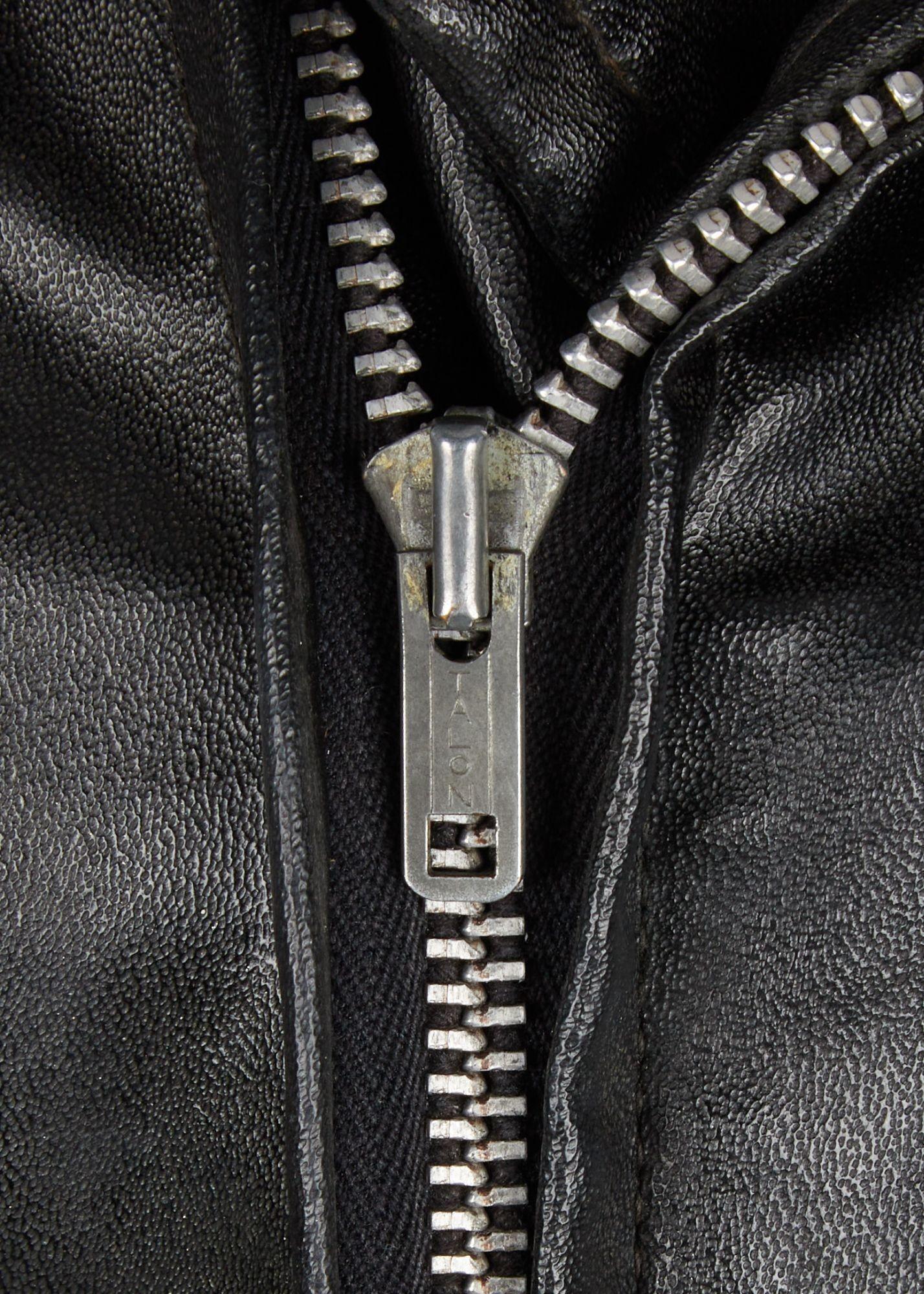 a close up of a zipper on a black leather jacket .