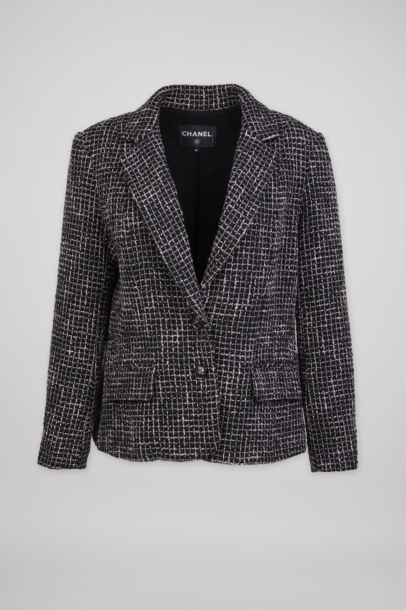 a black and white chanel blazer is on a white background .