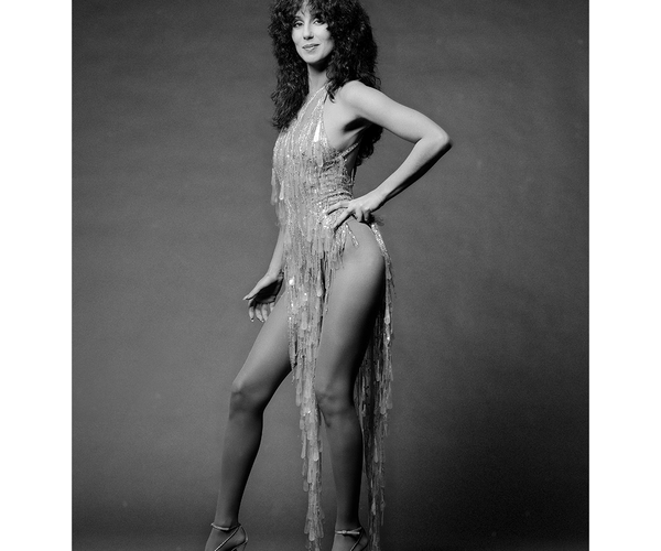 a black and white photo of cher in a very short dress