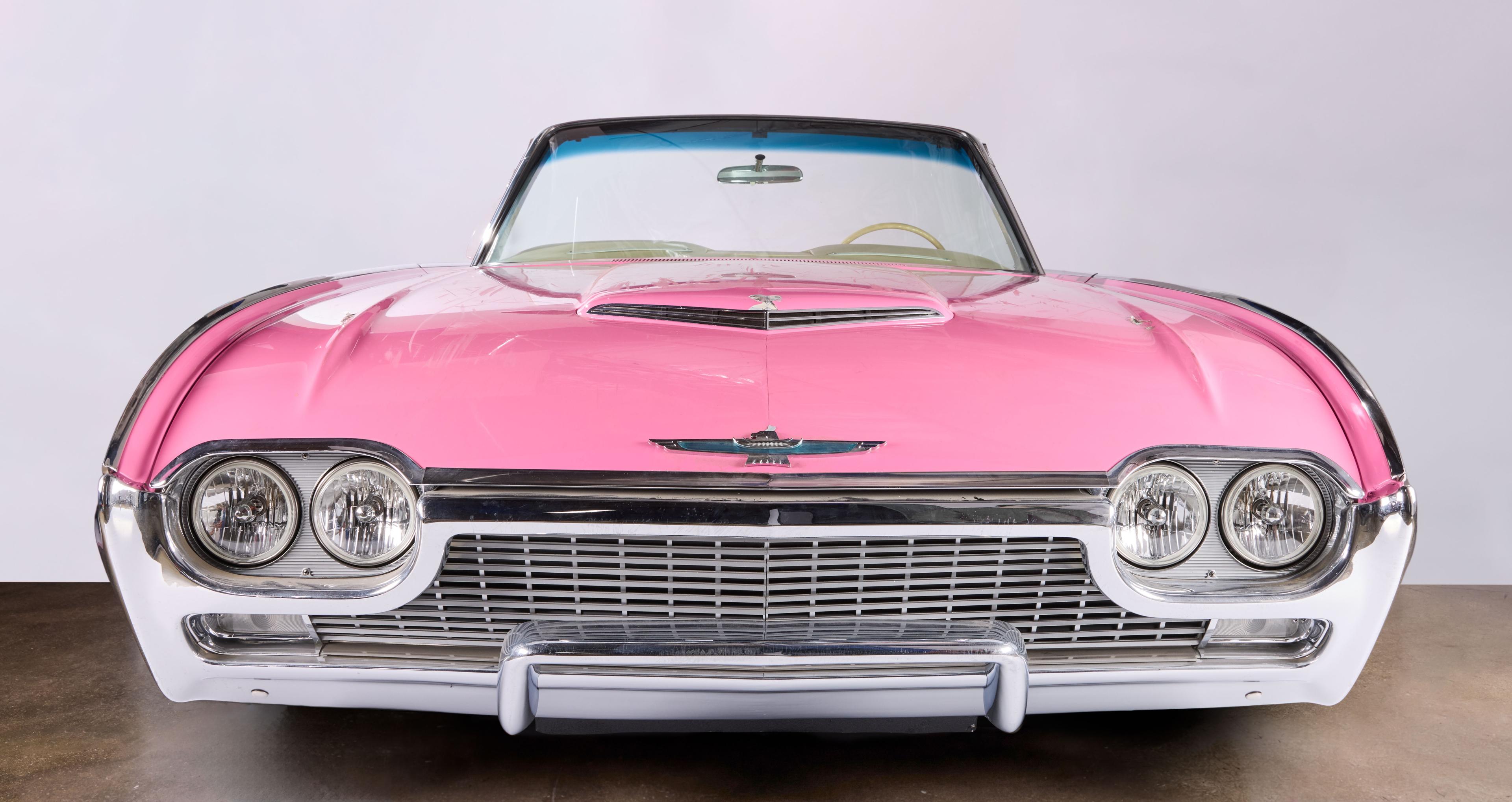 Front view of a vintage pink Ford Thunderbird convertible.