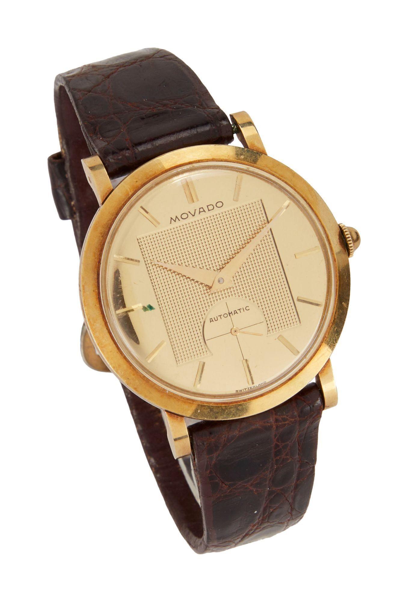 a gold movado automatic watch with a brown leather band