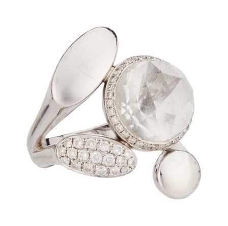 a silver ring with a clear stone and diamonds on a white background .