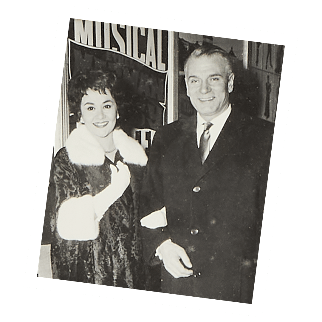 a black and white photo of a man and woman in front of a sign that says musical