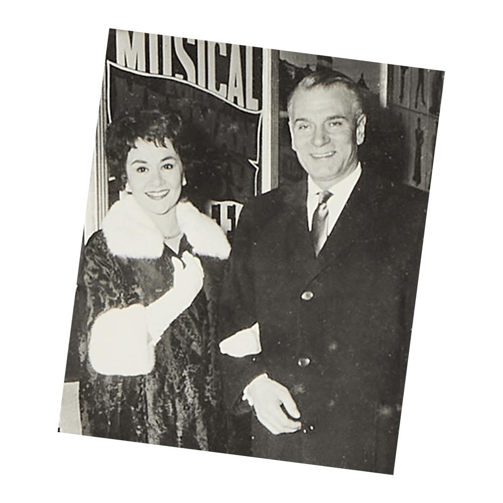 a black and white photo of a man and woman in front of a sign that says musical