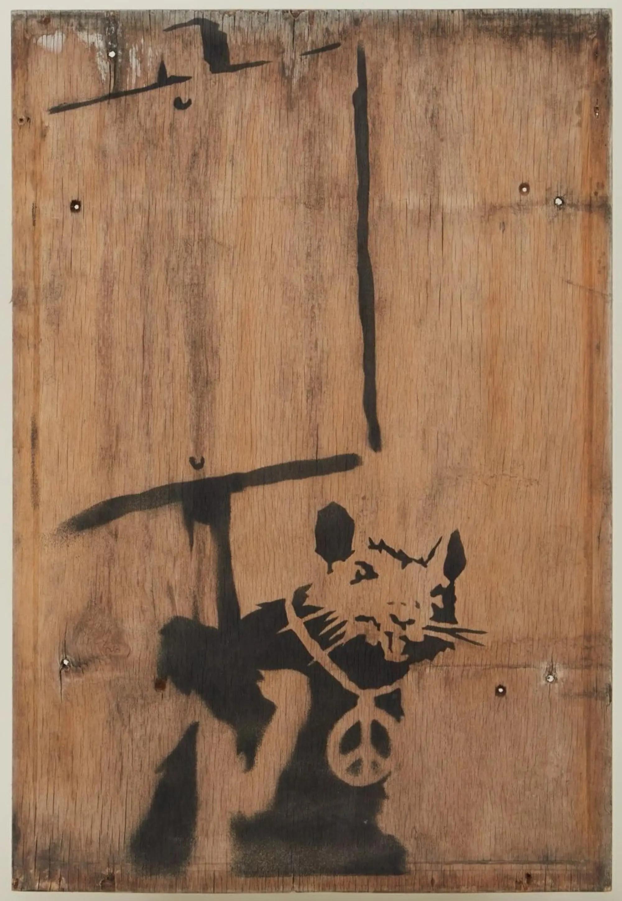 Banksy | "Placard Rat" Original London Street Art Painting (with Magazine) Black stencil of a rat holding a sign and wearing a peace symbol necklace on a wooden board.