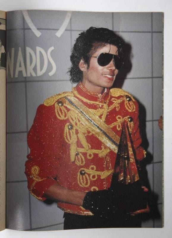 magazine photo of michael jackson wearing black glove and holding an american music award