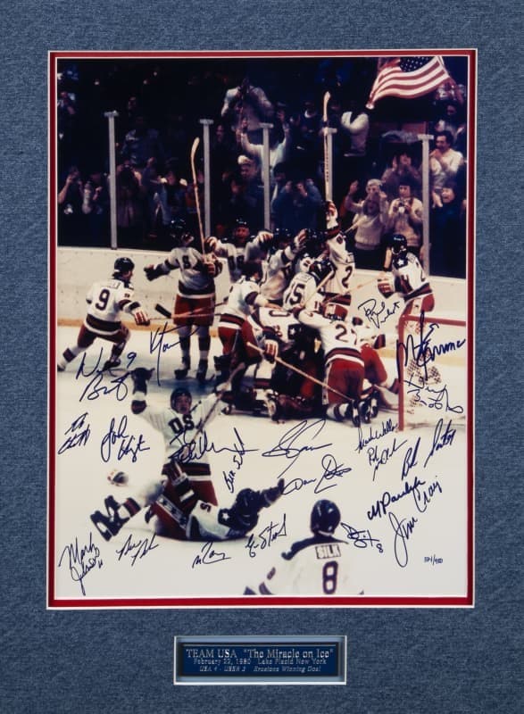 Autographed photo of the US "Miracle on Ice" Olympic hockey team celebrating their 1980 victory, with an American flag and a commemorative plaque.