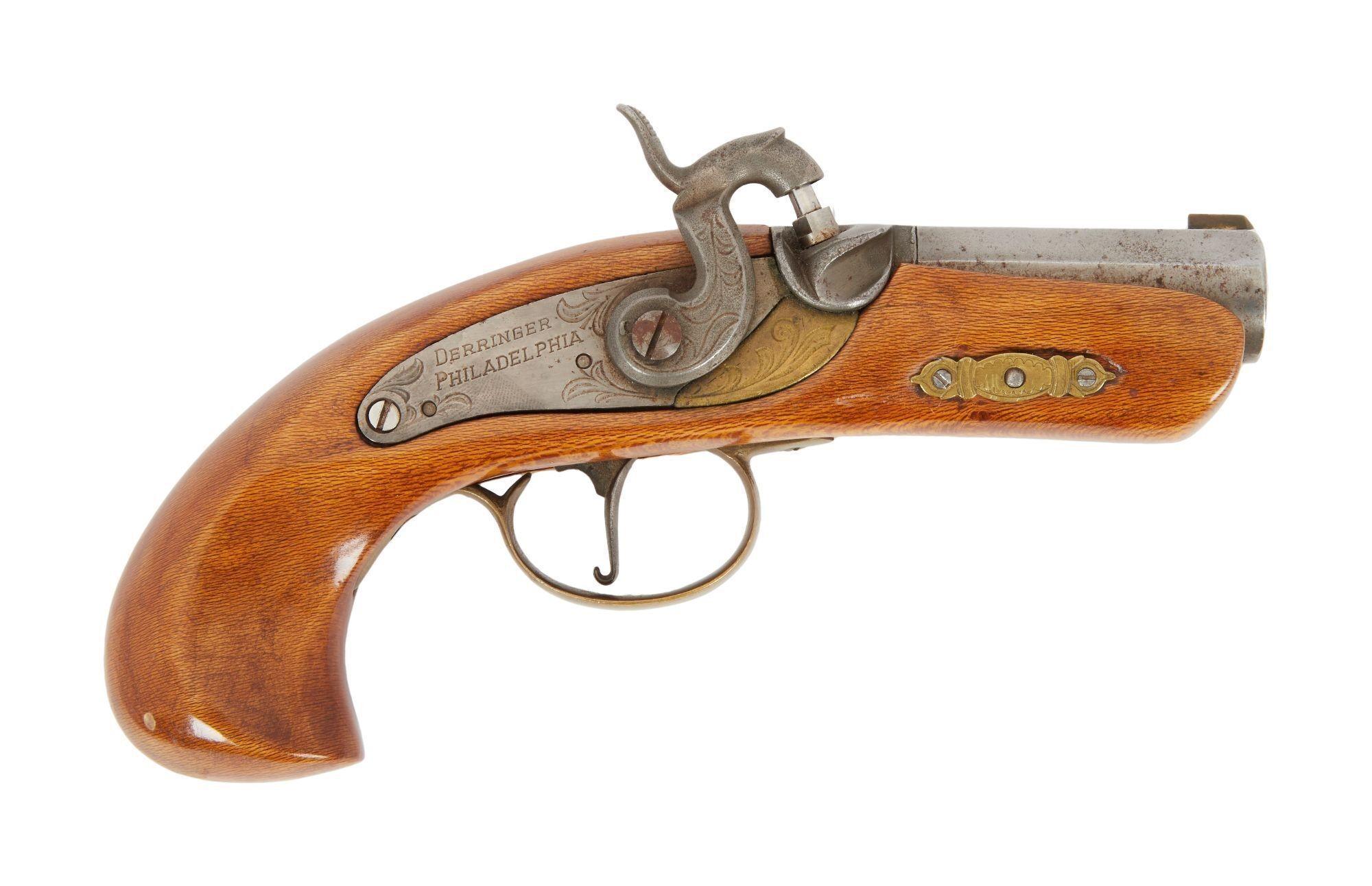 a small antique pistol with a wooden handle on a white background .