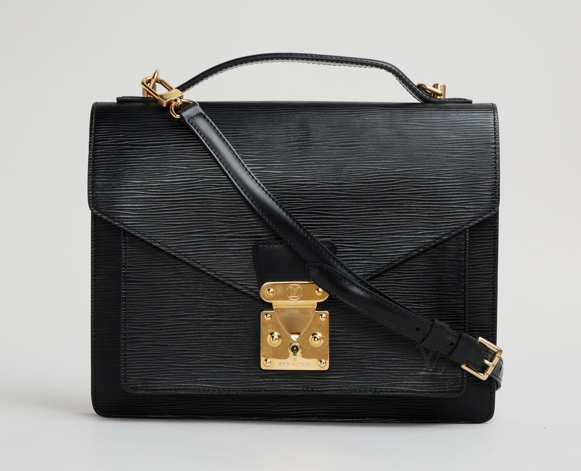 Lot #47. Elizabeth Taylor | 1994 Louis Vuitton Epi Leather Monceau Bag a black leather briefcase with a gold handle and strap on a white background .