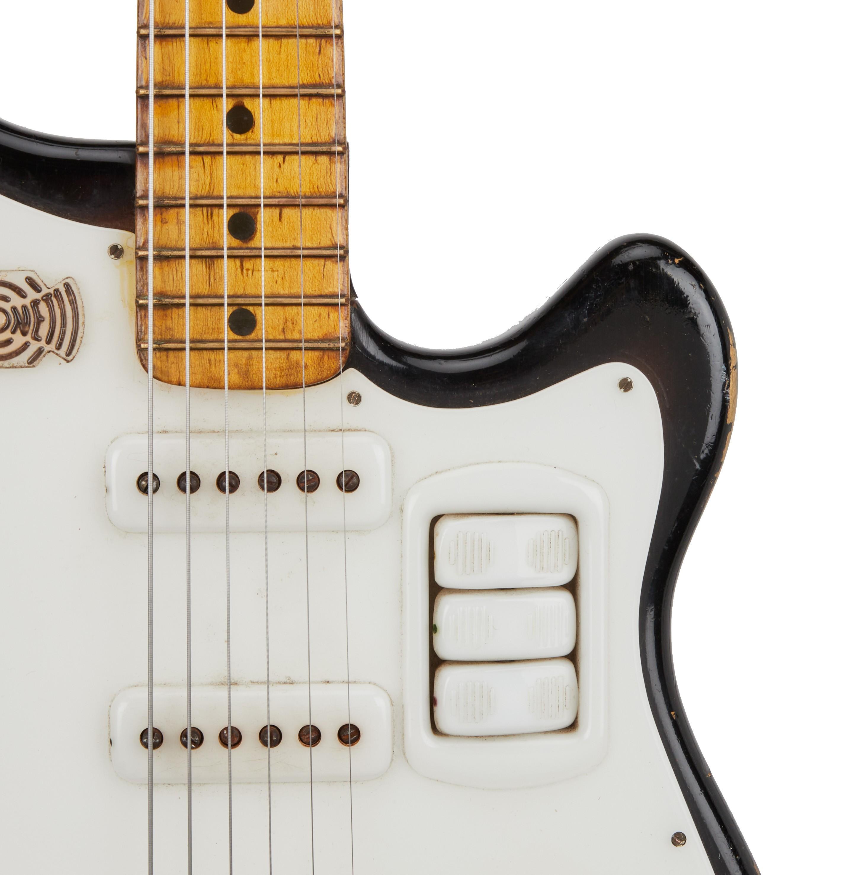 a close up of a black and white electric guitar