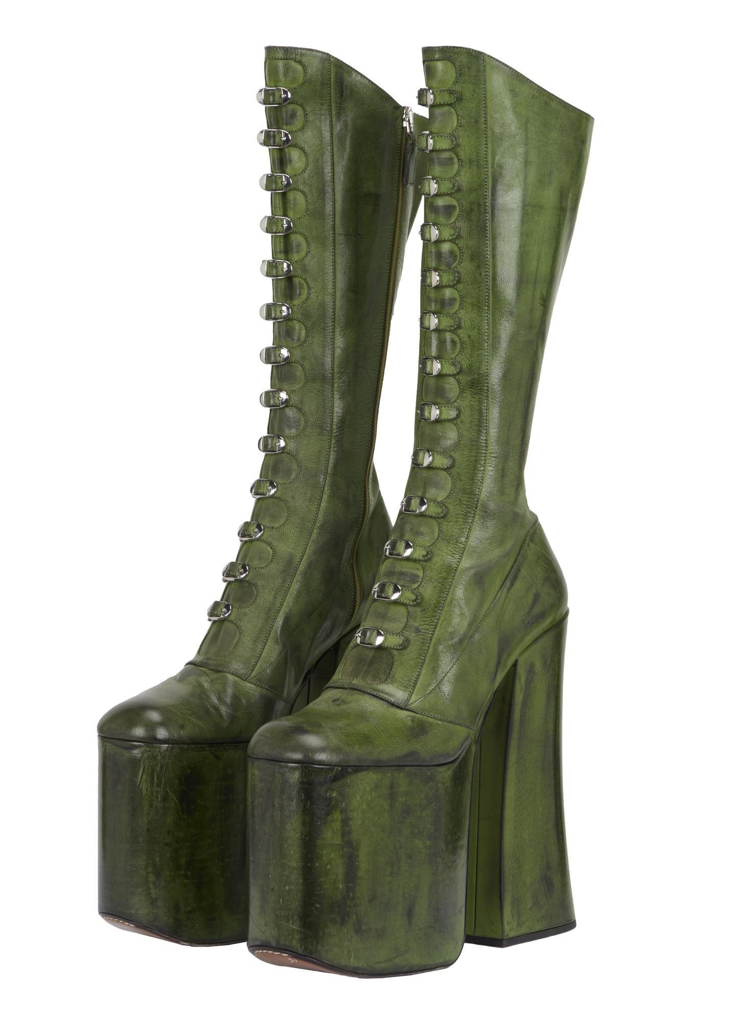 a pair of green platform boots on a white background
