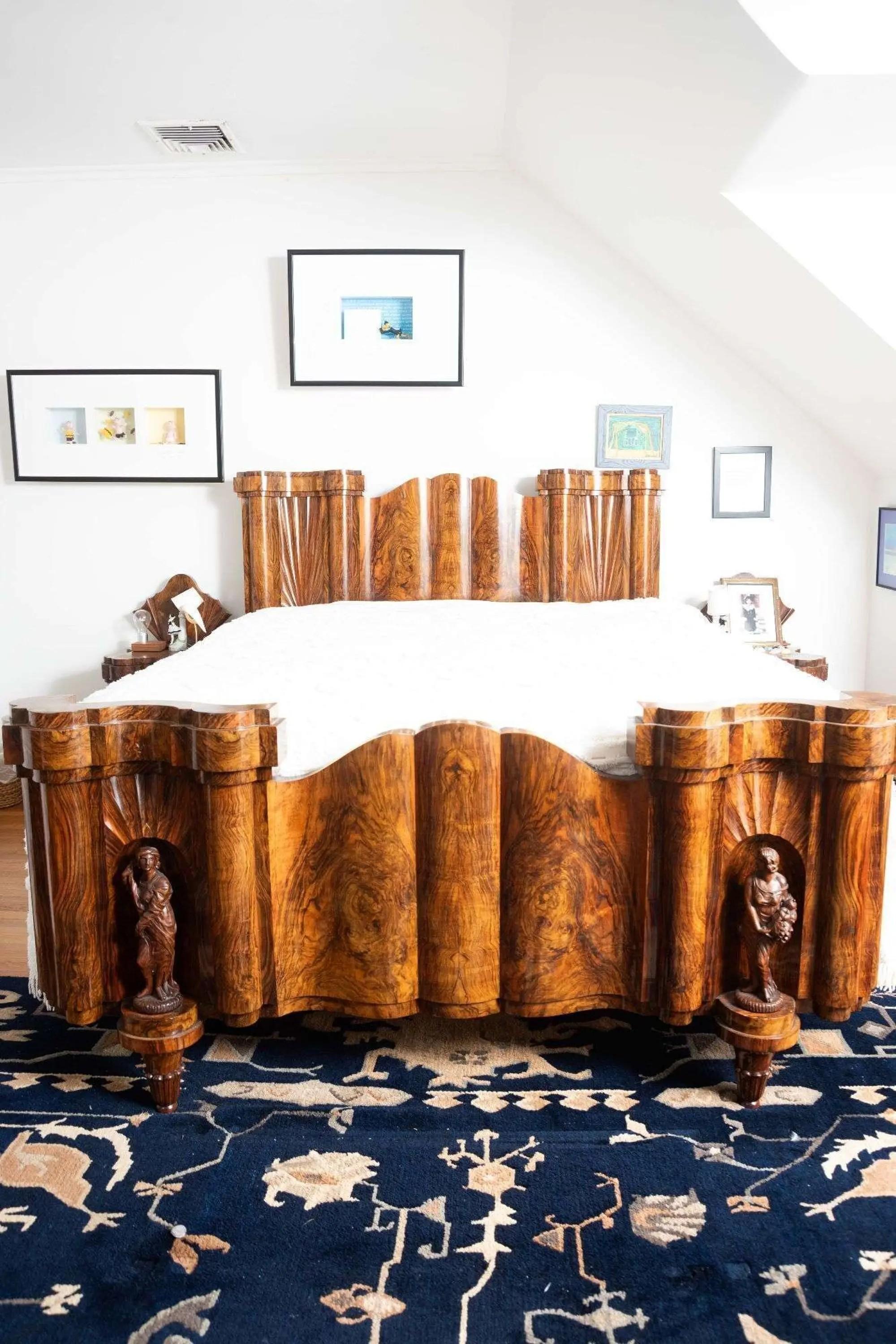 Lot #117. Whoopi Goldberg | Giovanni Guerrini Six Piece Bedroom Suite a wooden bed frame with white mattress and blue rug