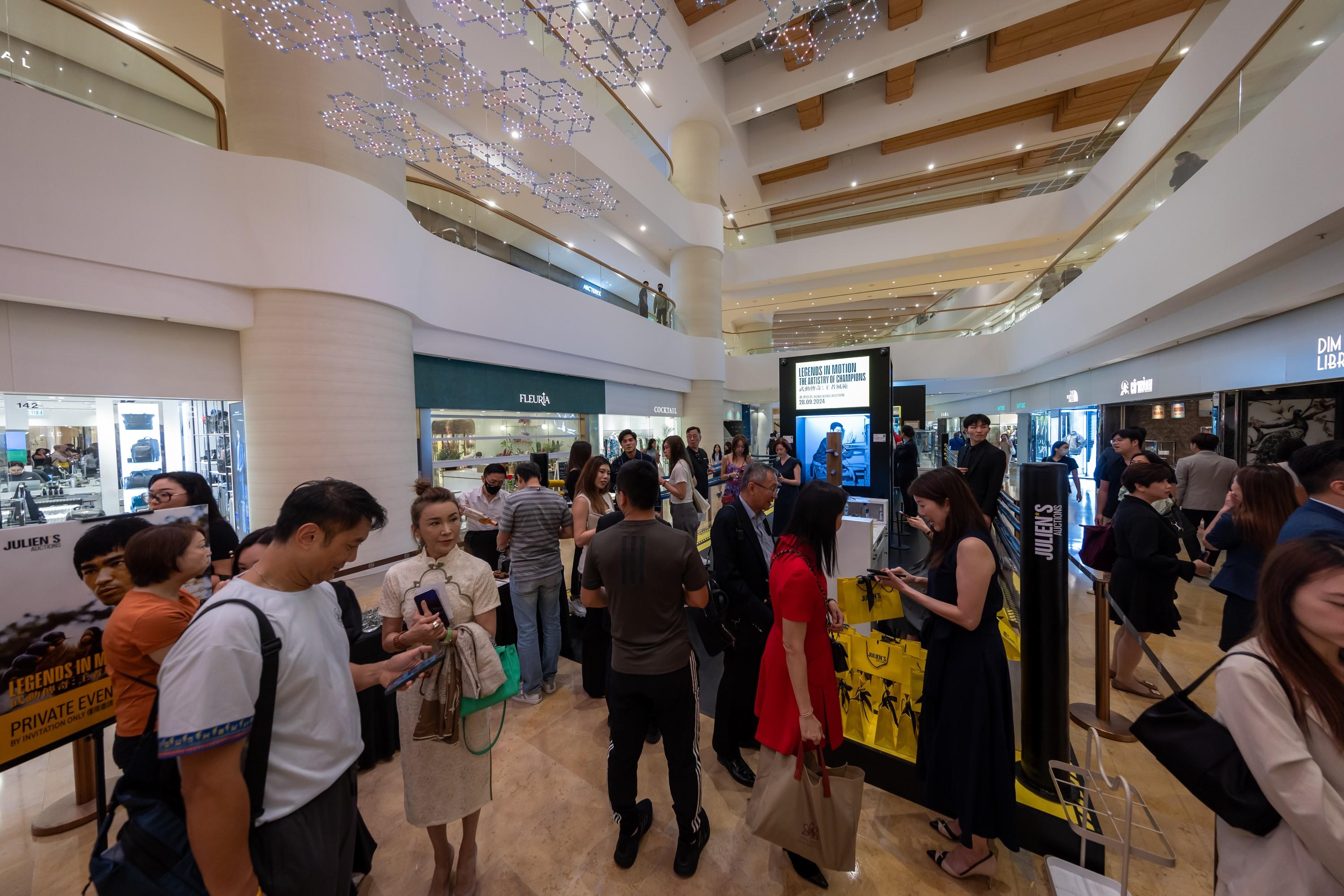 a large group of people are standing in a mall .