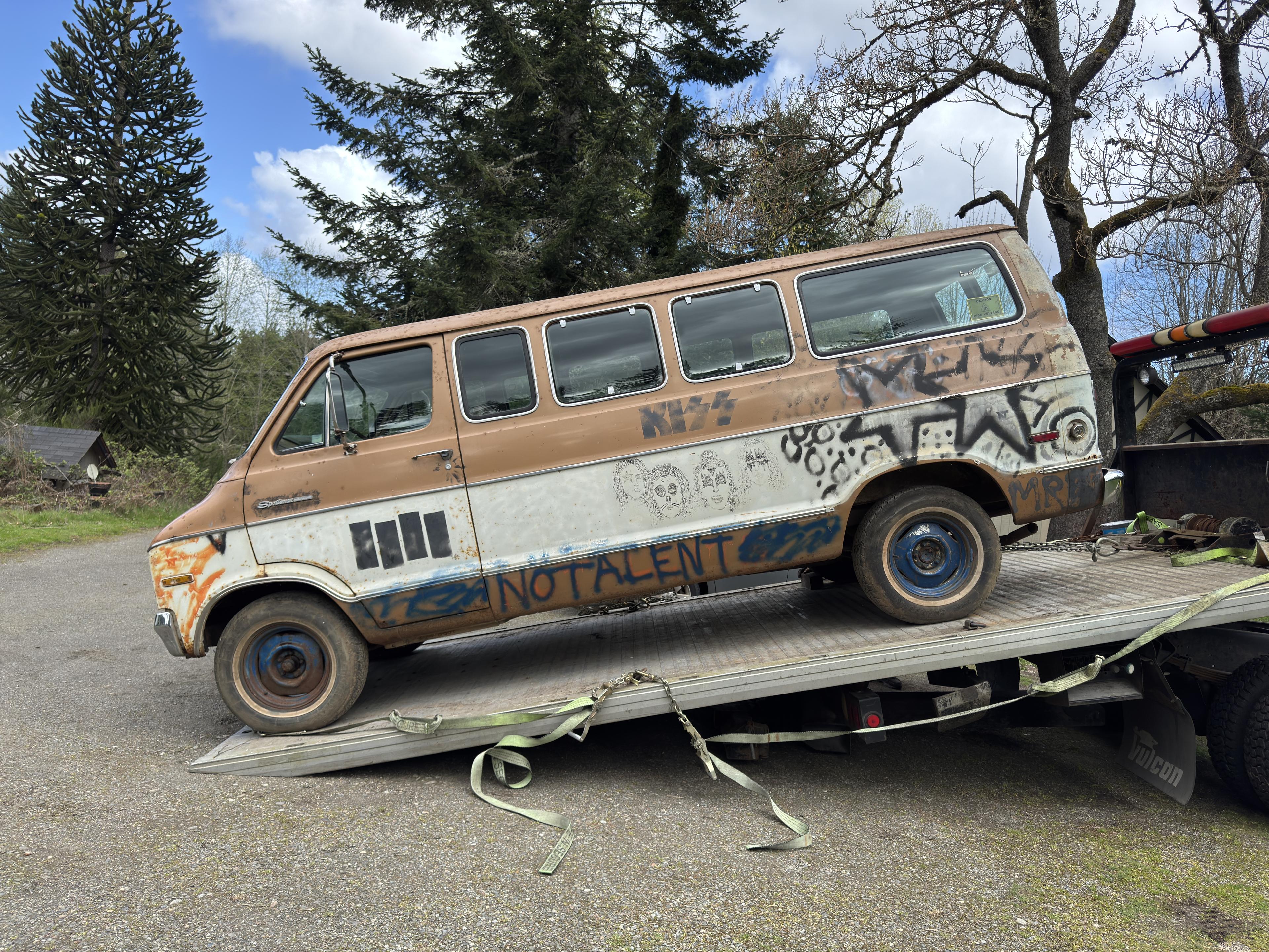 a van sits on the bed of a tow truck