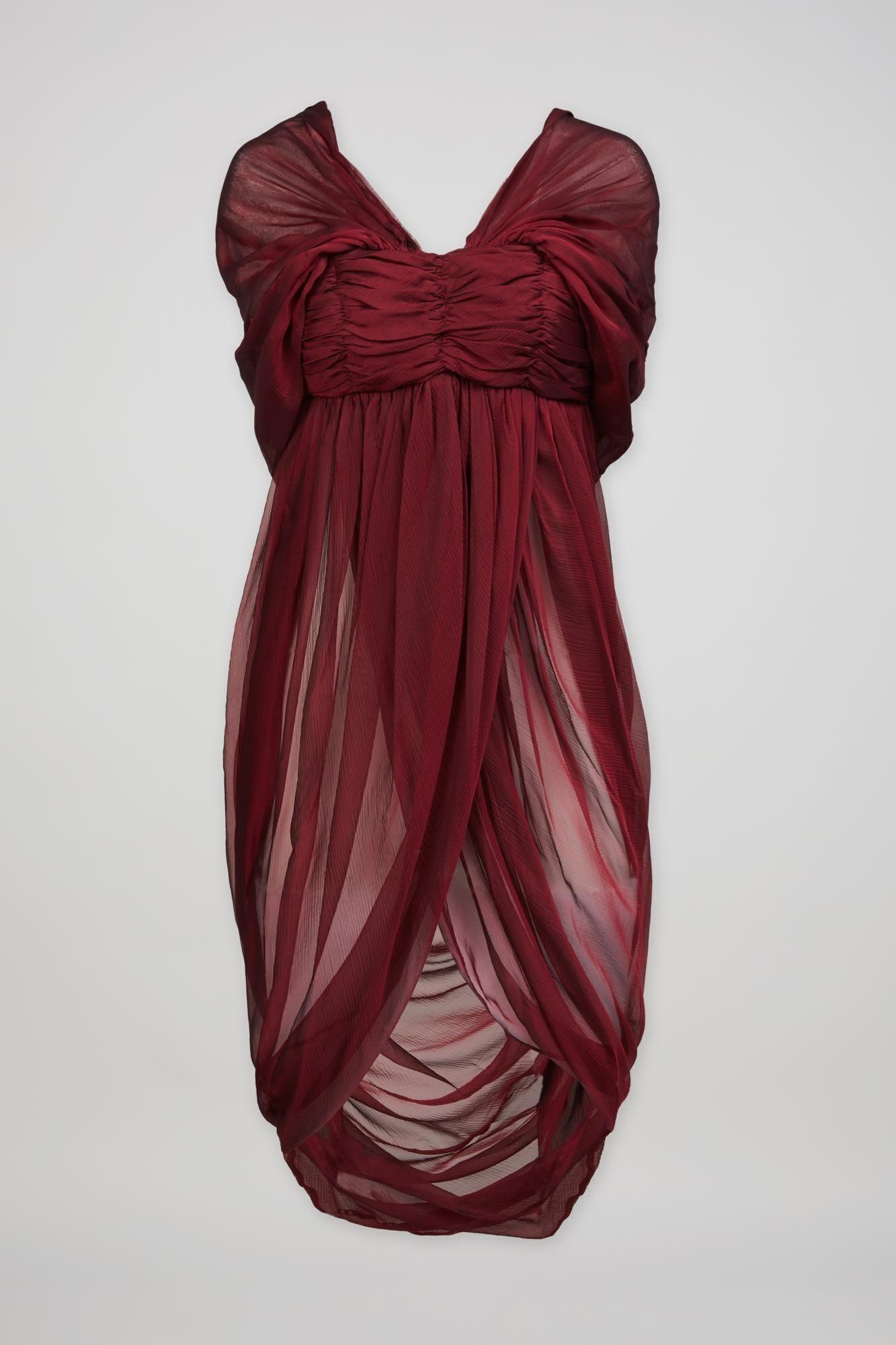 a burgundy dress is draped over a white background