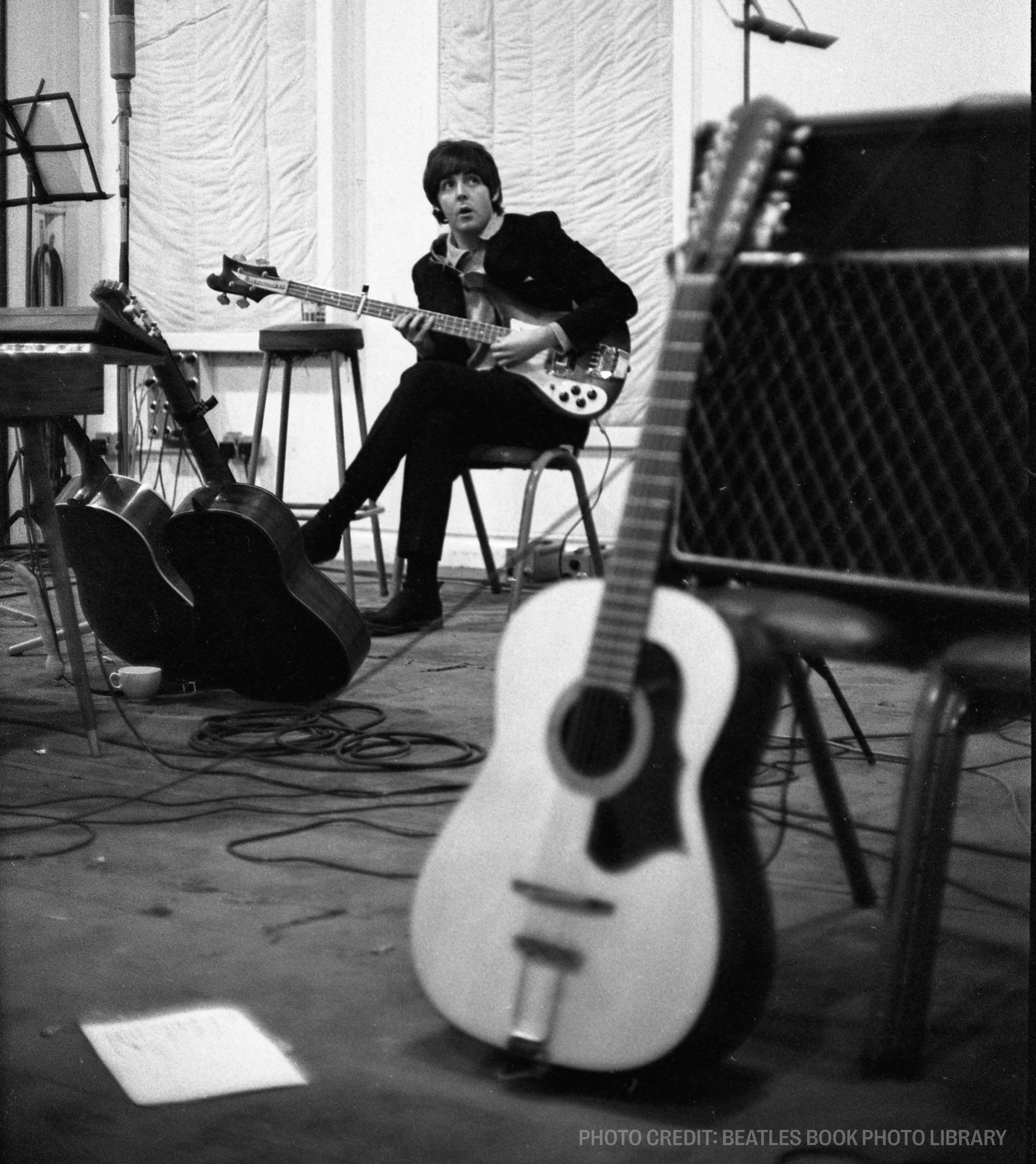 a black and white photo of a man playing a guitar