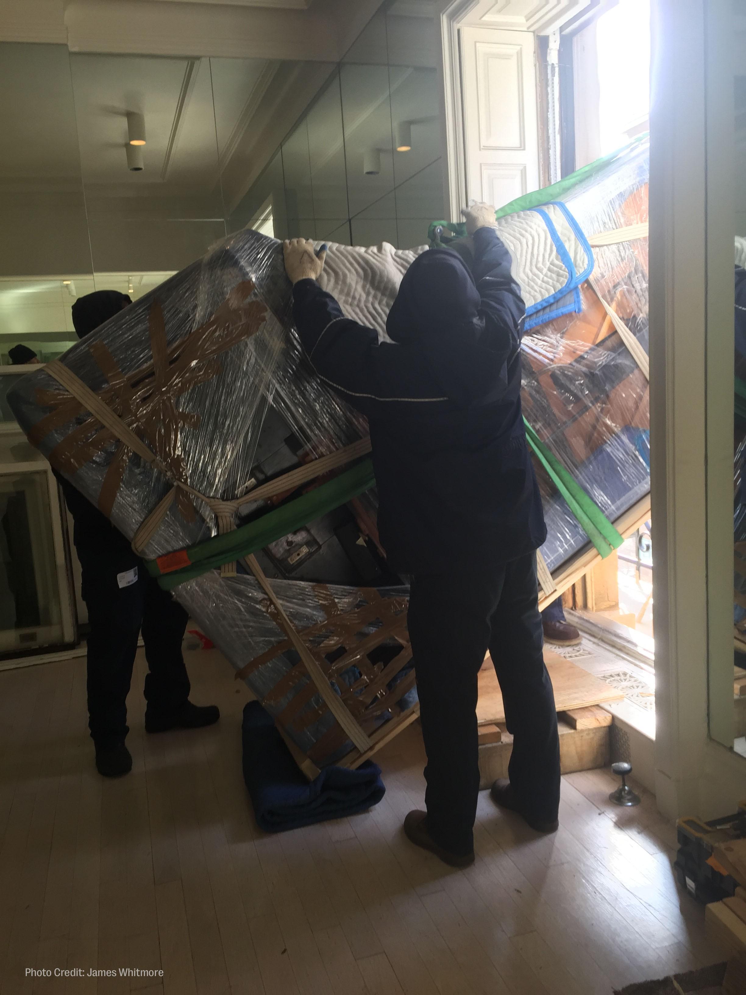 workers hoist roberta flack's piano out of her new york city apartment window.
