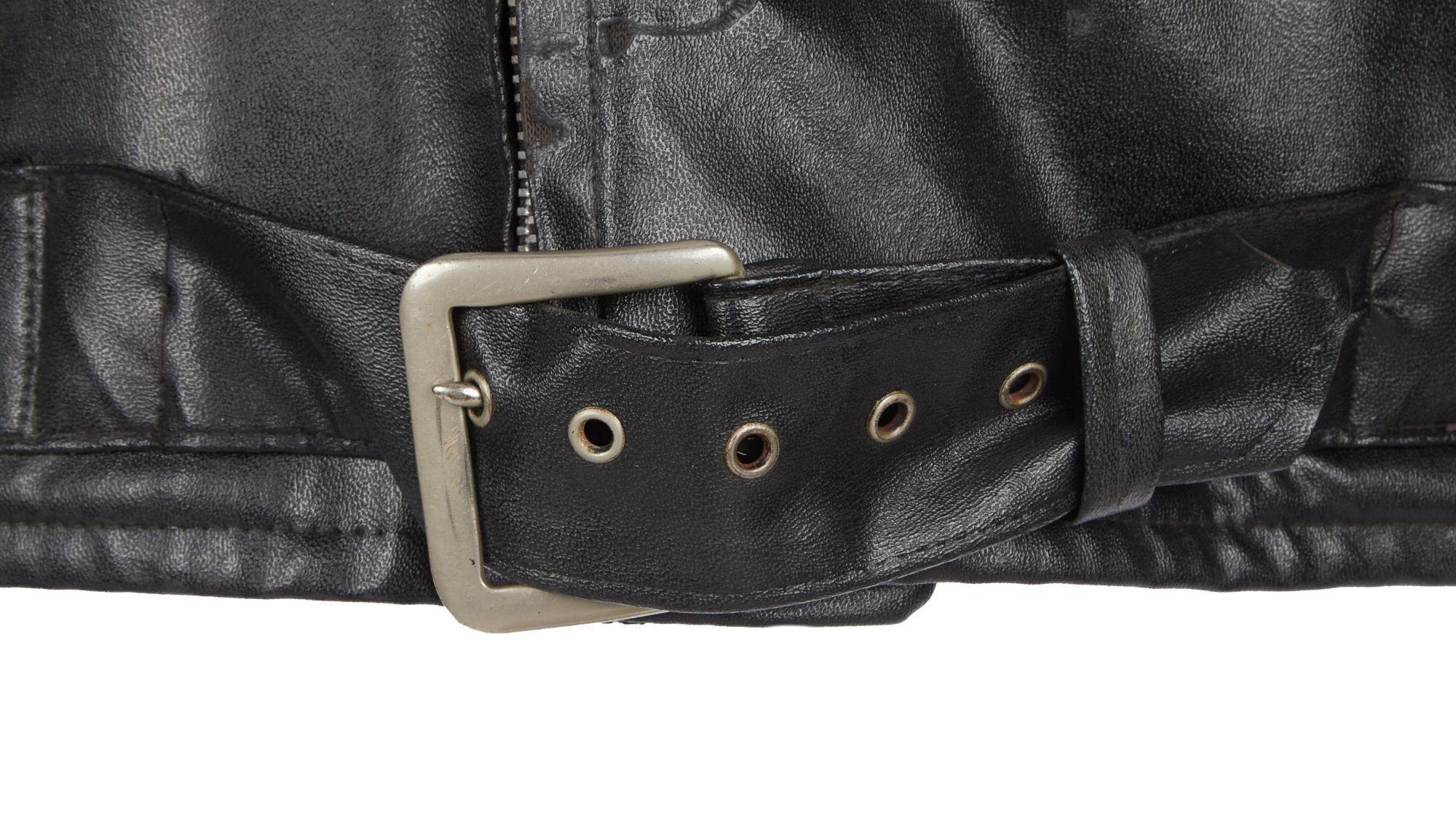 a close up of a black leather jacket with a silver buckle .