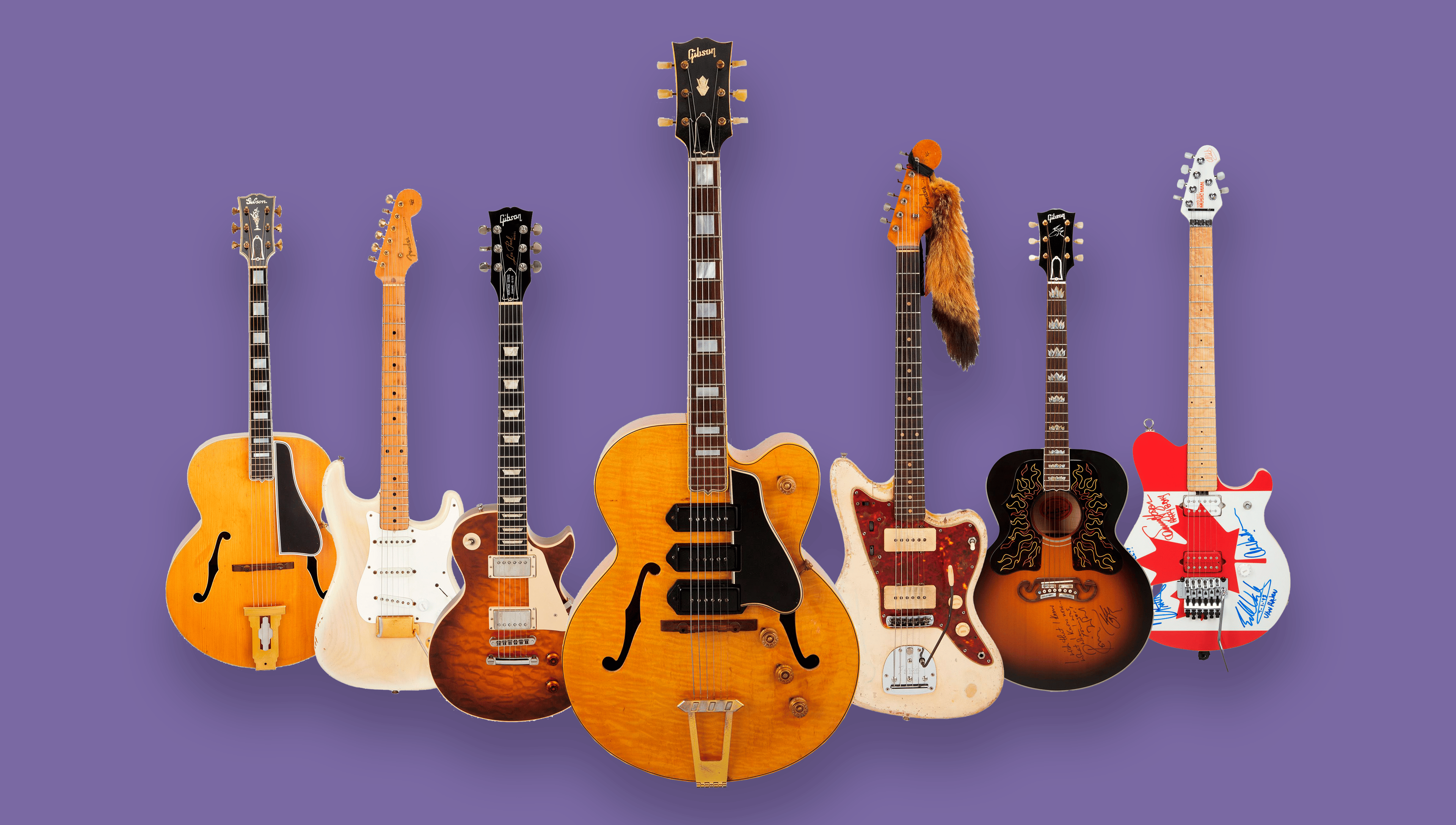 a group of guitars are lined up from Played, Worn and Torn Auction