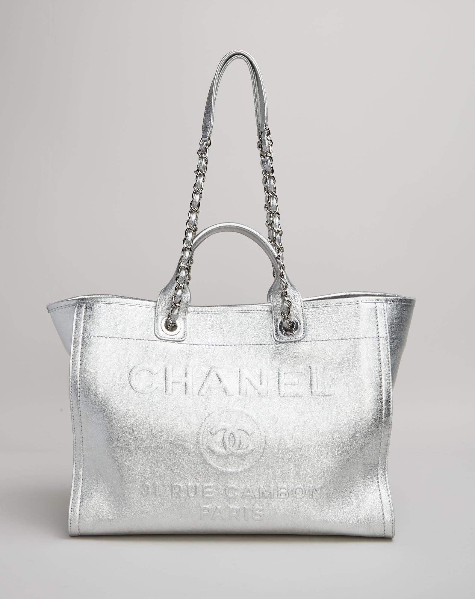 a silver chanel tote bag with a chain handle