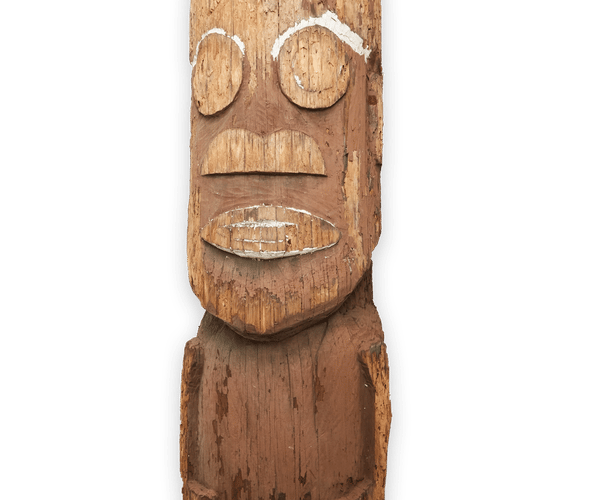 a wooden totem pole with a face carved into it