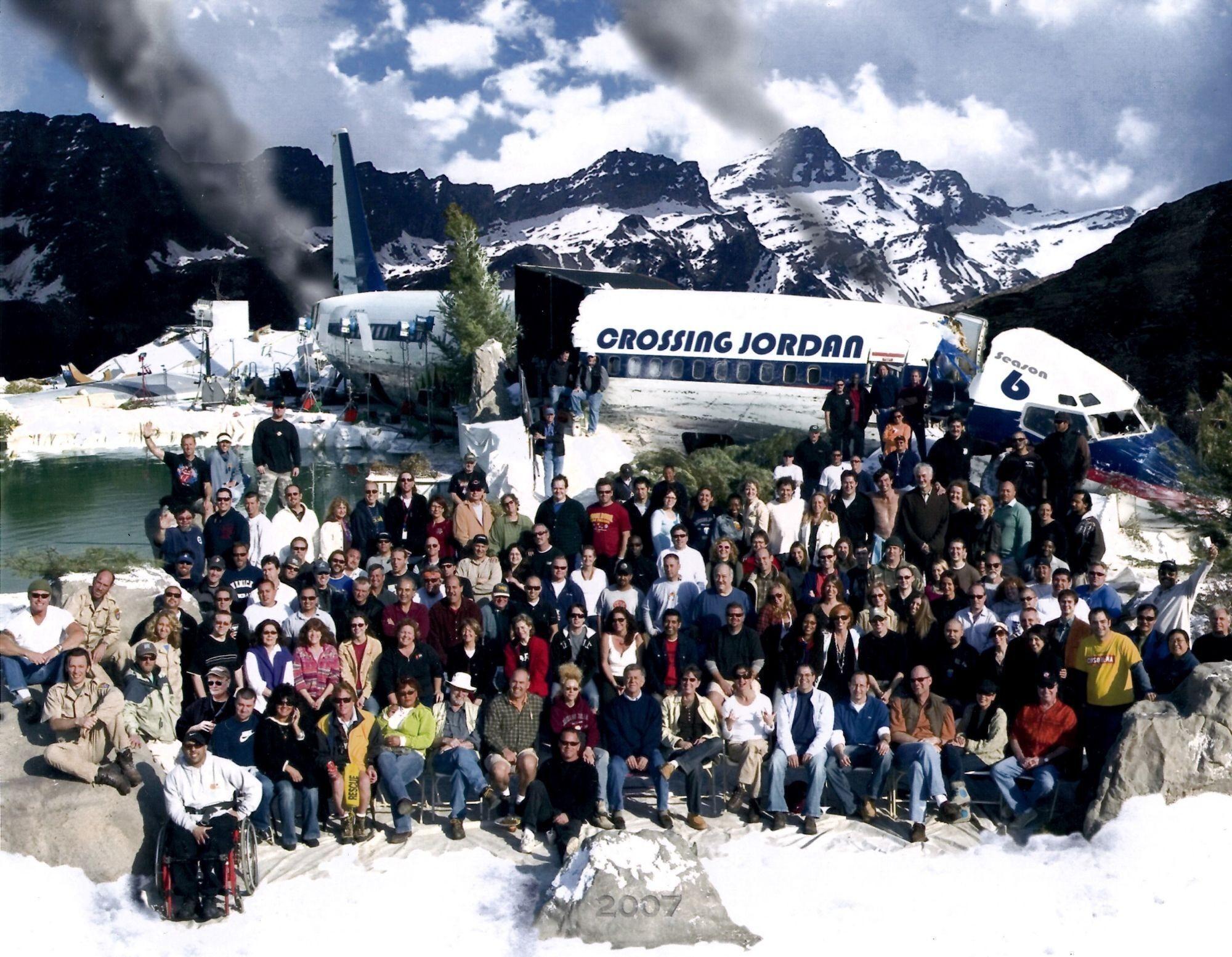 a large group of people are posing in front of a crossing jordan plane