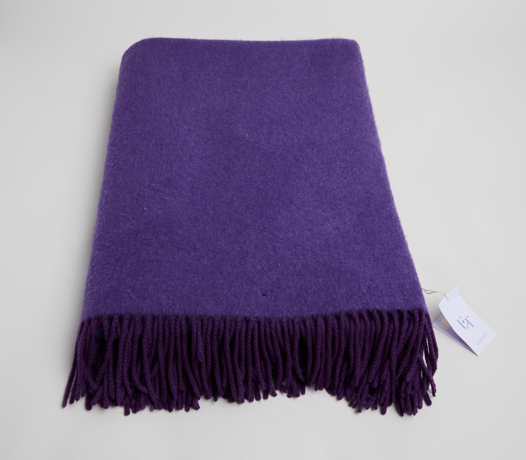 Lot #23. Elizabeth Taylor | Hermes Violet Cashmere Throw a purple blanket with fringe is sitting on a white surface .